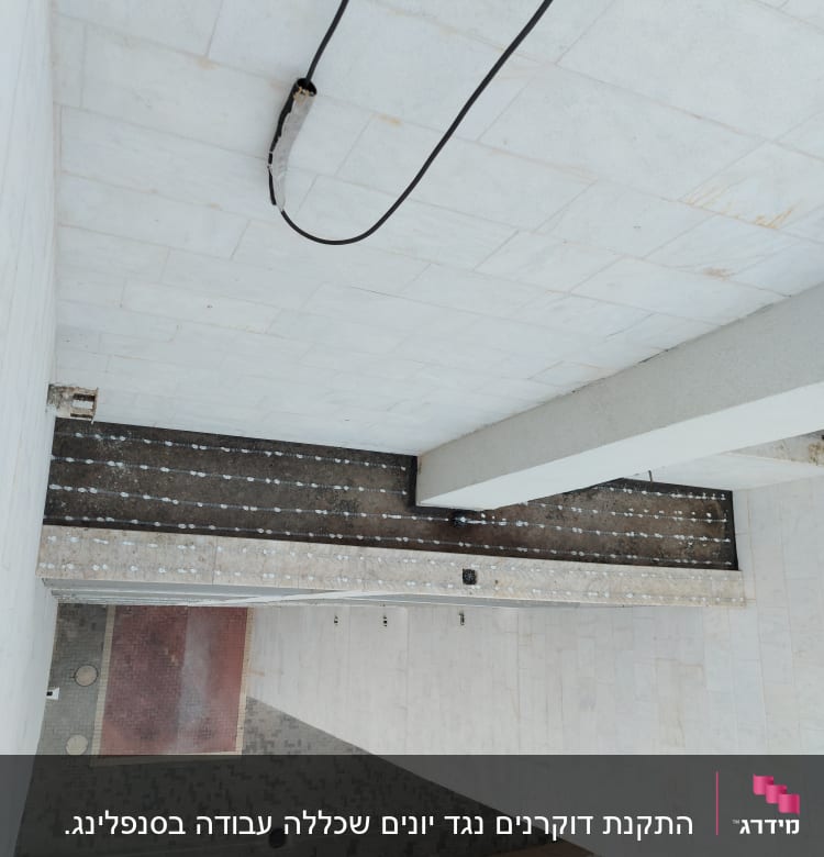 חוט חשמל תלוי על תקרה לבנה